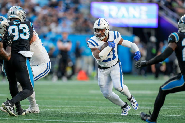 Nov 5, 2023; Charlotte, North Carolina, USA; Indianapolis Colts running back Zack Moss (21) runs through an opening defended by Carolina Panthers defensive tackle LaBryan Ray (93) during the first quarter at Bank of America Stadium. Mandatory Credit: Jim Dedmon-USA TODAY Sports